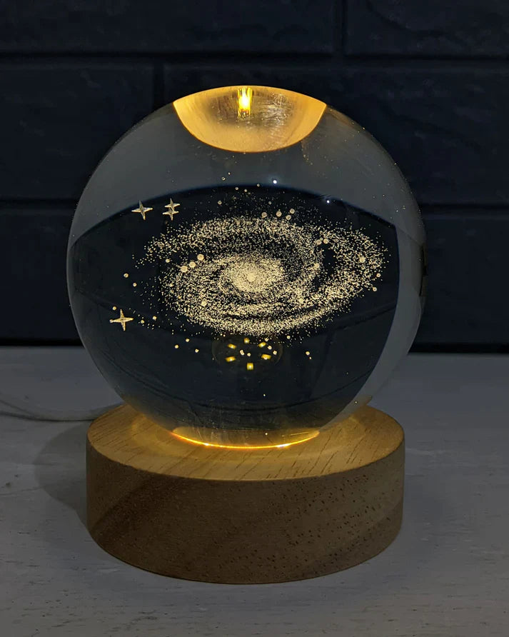 3D laser-engraved crystal planet ball glowing on a wooden LED base in a modern bedroom