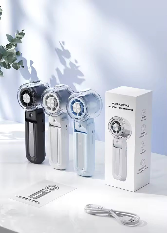 USB rechargeable portable mini fan with ice cooling chamber and mist spray being used outdoors on a hot summer day